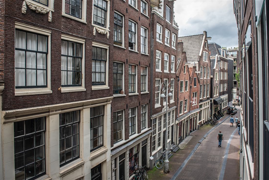 Brick canal houses opposite, seen from an upper window on a bright day.